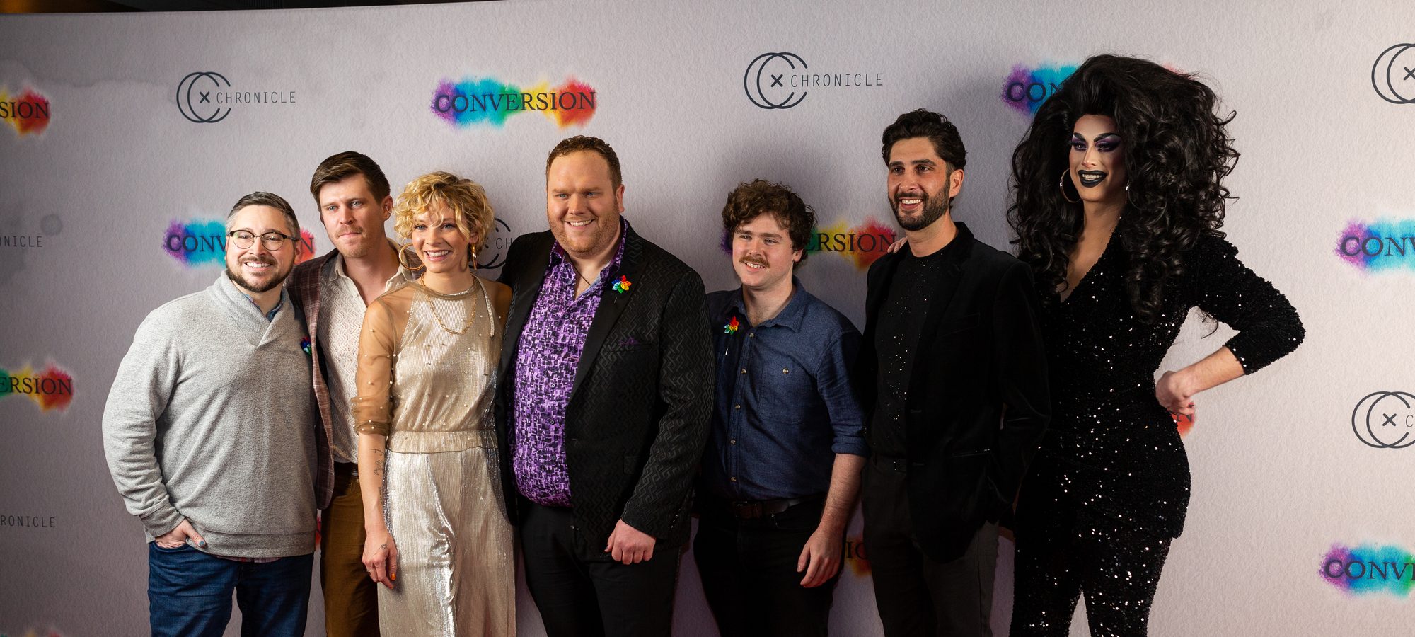The cast and crew of Conversion lined up together on the red carpet at the premiere, in front of a Chronicle Cinema step and repeat