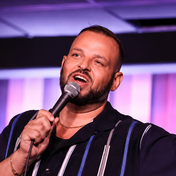 Daniel Franzese on stage with a microphone