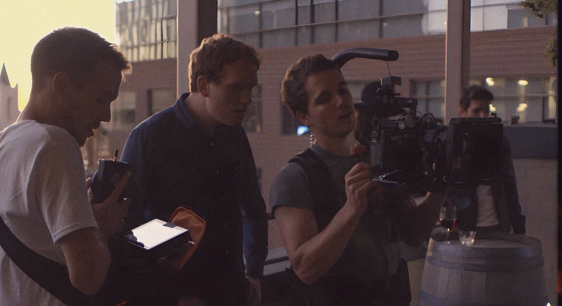 Zach Meiners, Sam Windell, and Isaac Harrison huddled around a camera rig on set in Greenville, South Carolina, in September 2014