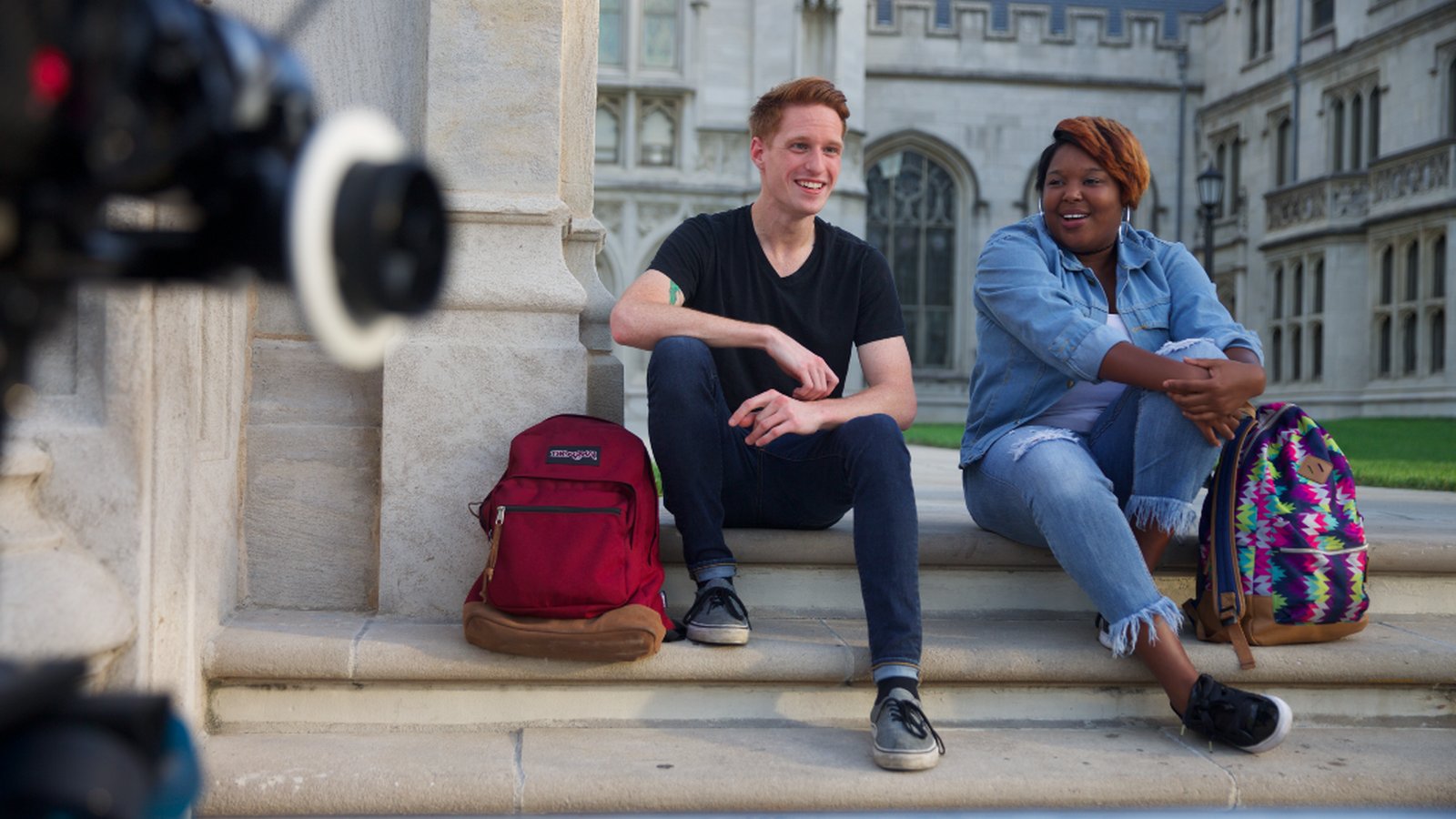 Two college students sit on the steps of Jefferson Community & Technical College as an Arri Alexa camera films them.
