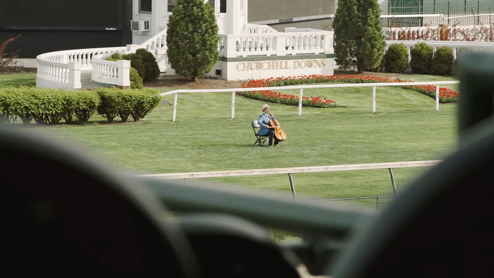 A lone cellist plays in the winner's circle of an empty Churchill Downs.