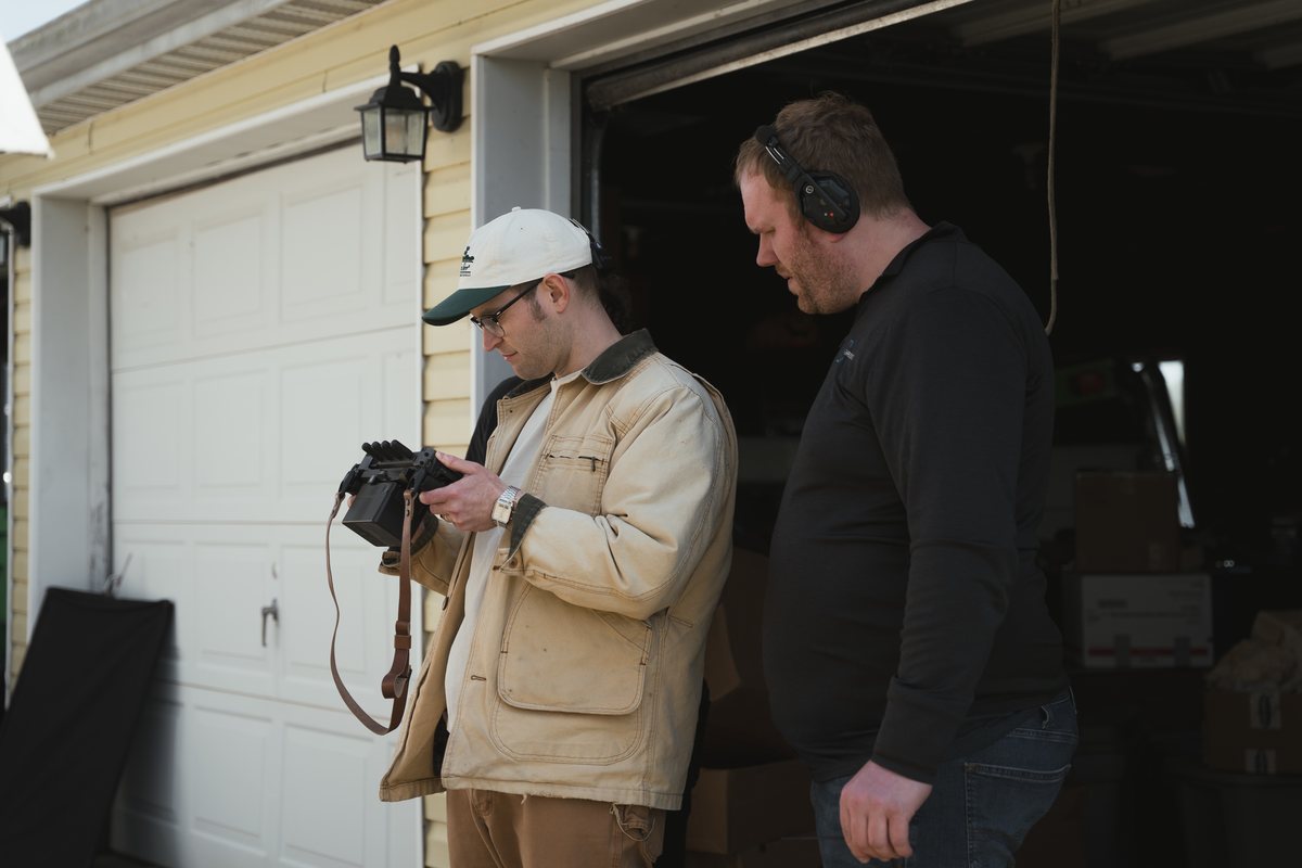 Producer Zach Meiners and director Max Moore collaborate on set beside camera and lighting gear.