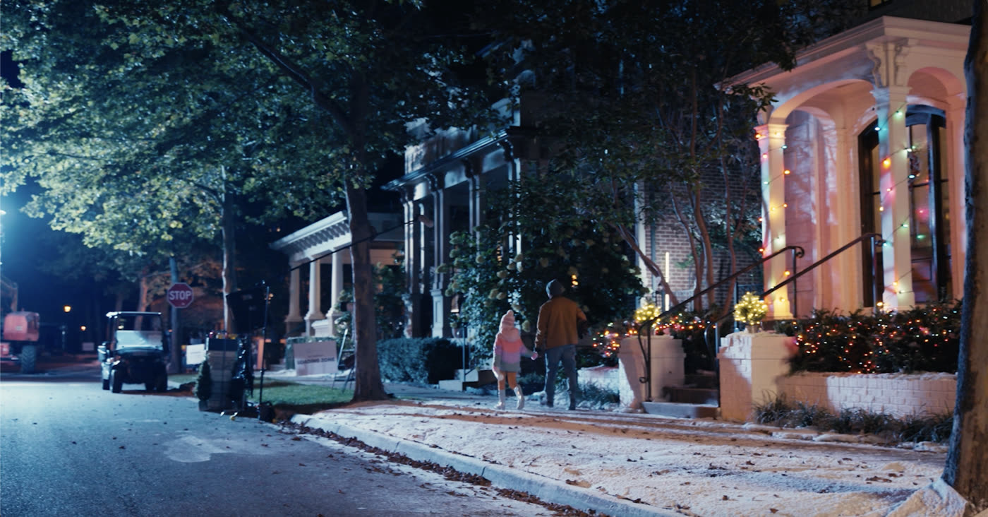 Behind the scenes on the Hallmark Winter Walk shoot of fake snow in front of a house in a neighborhood creating a Christmas scene in August.